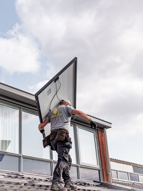 Montážny tím SolarPeak inštaluje celočierne fotovoltaické panely na šikmej streche